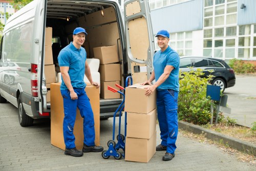 Removalists carrying furniture through a Clapham flat with stair access